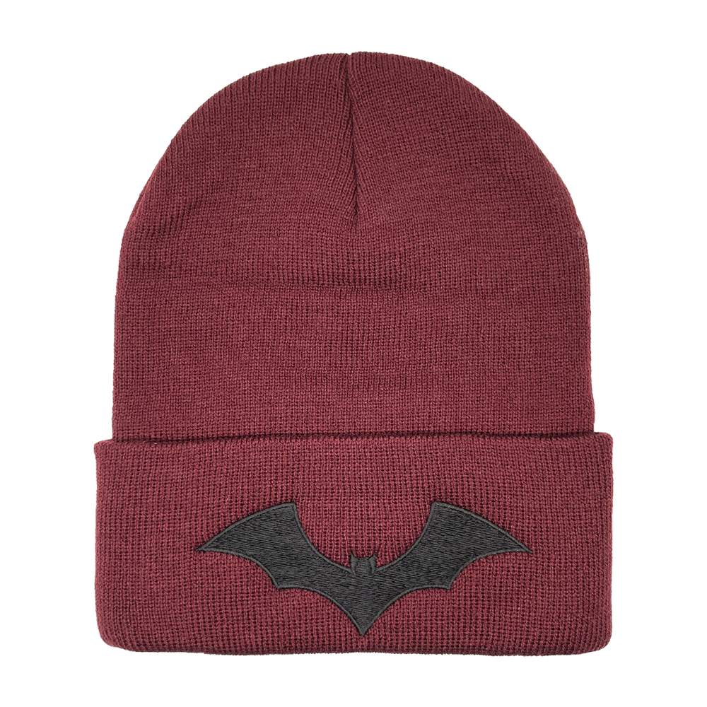 A maroon red beanie with embroidered SIM logo and bat design. 